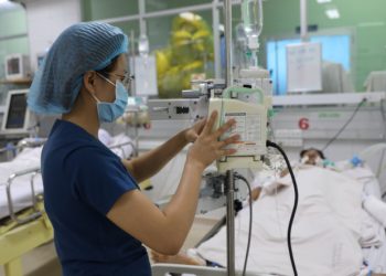 Nhân viên y tế điều chỉnh dịch truyền cho một bệnh nhân sốt xuất huyết nặng tại Bệnh viện Bệnh Nhiệt đới TP HCM, ngày 28/6. Ảnh: Quỳnh Trần