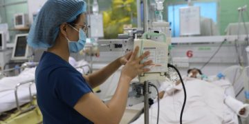 Nhân viên y tế điều chỉnh dịch truyền cho một bệnh nhân sốt xuất huyết nặng tại Bệnh viện Bệnh Nhiệt đới TP HCM, ngày 28/6. Ảnh: Quỳnh Trần