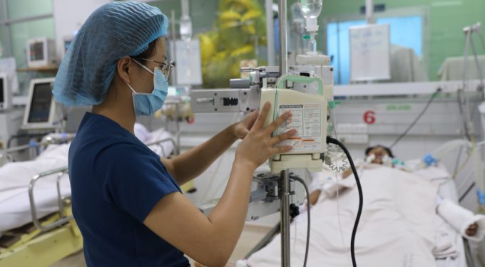 Nhân viên y tế điều chỉnh dịch truyền cho một bệnh nhân sốt xuất huyết nặng tại Bệnh viện Bệnh Nhiệt đới TP HCM, ngày 28/6. Ảnh: Quỳnh Trần