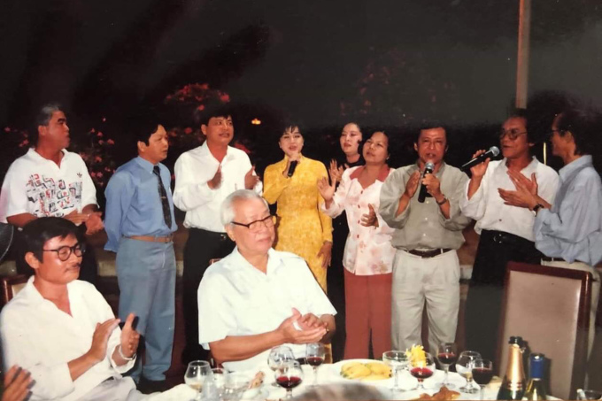 Nhà thơ Nguyễn Duy (ngồi, phía trái) bên cố Thủ tướng Võ Văn Kiệt (ngồi) và Trịnh Công Sơn (đứng, bên phải) cùng hát Nối vòng tay lớn (Trịnh Công Sơn sáng tác) bên sông Sài Gòn năm 1999. Ảnh: Nhân vật cung cấp